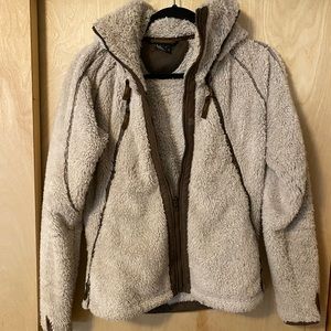 Kuhl Sherpa jacket with tall collar holding hidden hood; thumb holes
